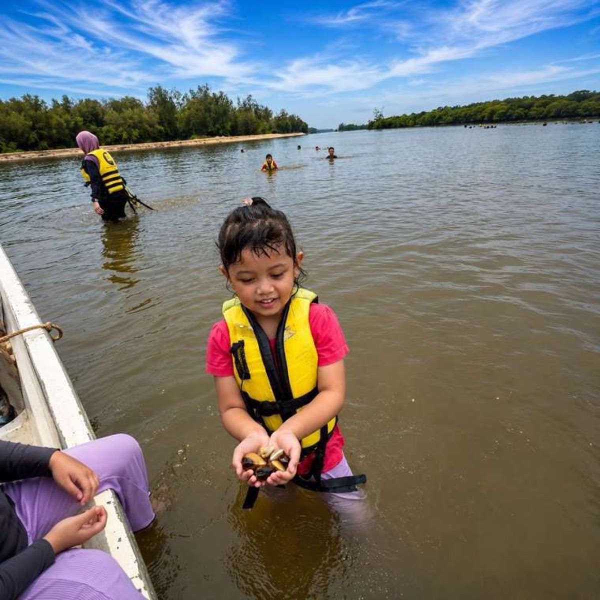 Child picking clams in the Setiu Wetlands